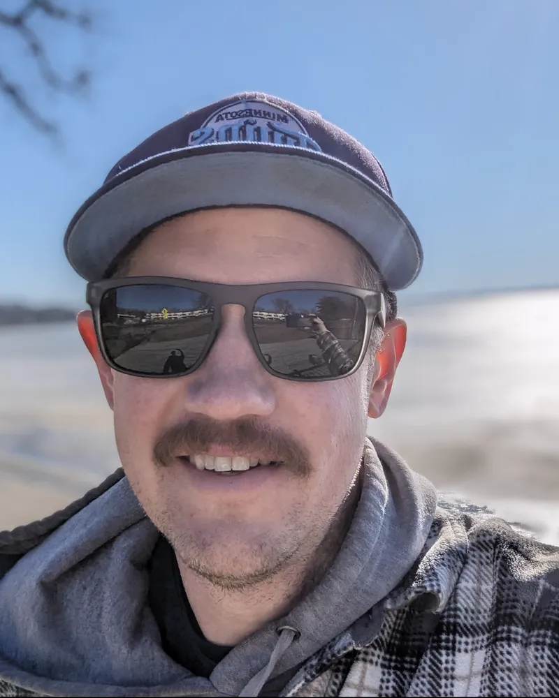 Jordan Damhof in a ball cap and sunglasses on a bright lakeside day